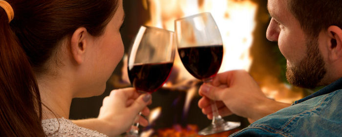 couple enjoying wine by the fireplace