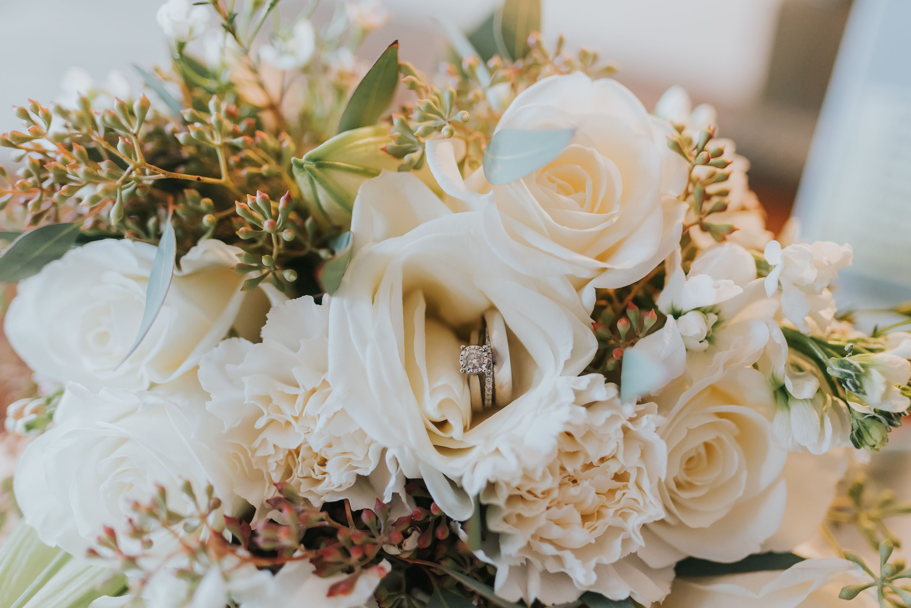 Bouquet of white roses with two wedding rings